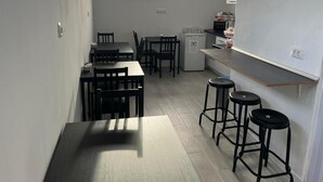 A compact kitchen with a dining area, a small refrigerator, and a window providing natural light. - B&B paraiso tenerife  (Los Abrigos)