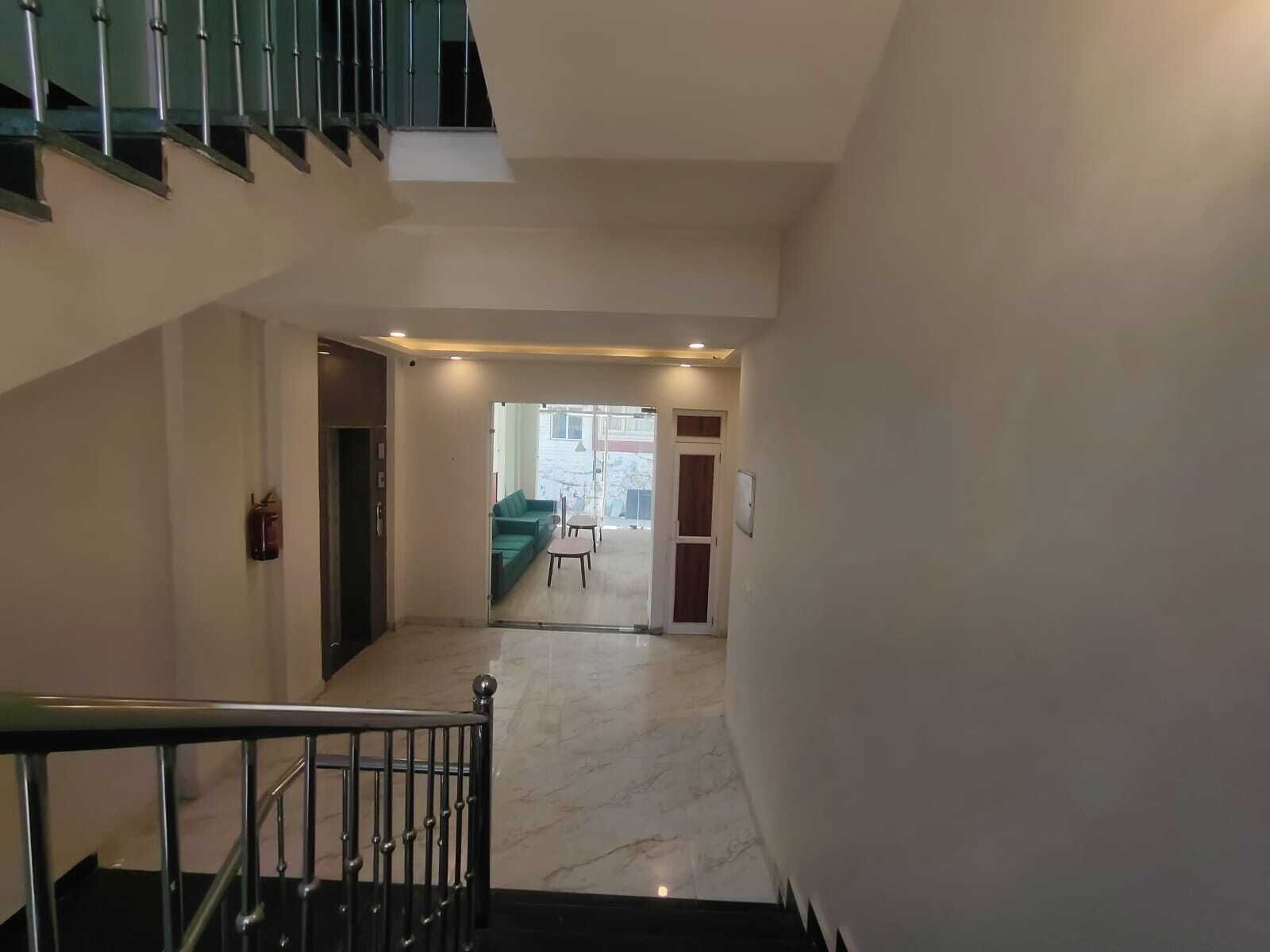 A staircase leading to a living area with a green sofa and a small table.