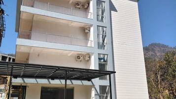 Un edificio de varios pisos con balcones, un letrero que dice "LA VISTA RESIDENCY" y un cielo despejado al fondo.