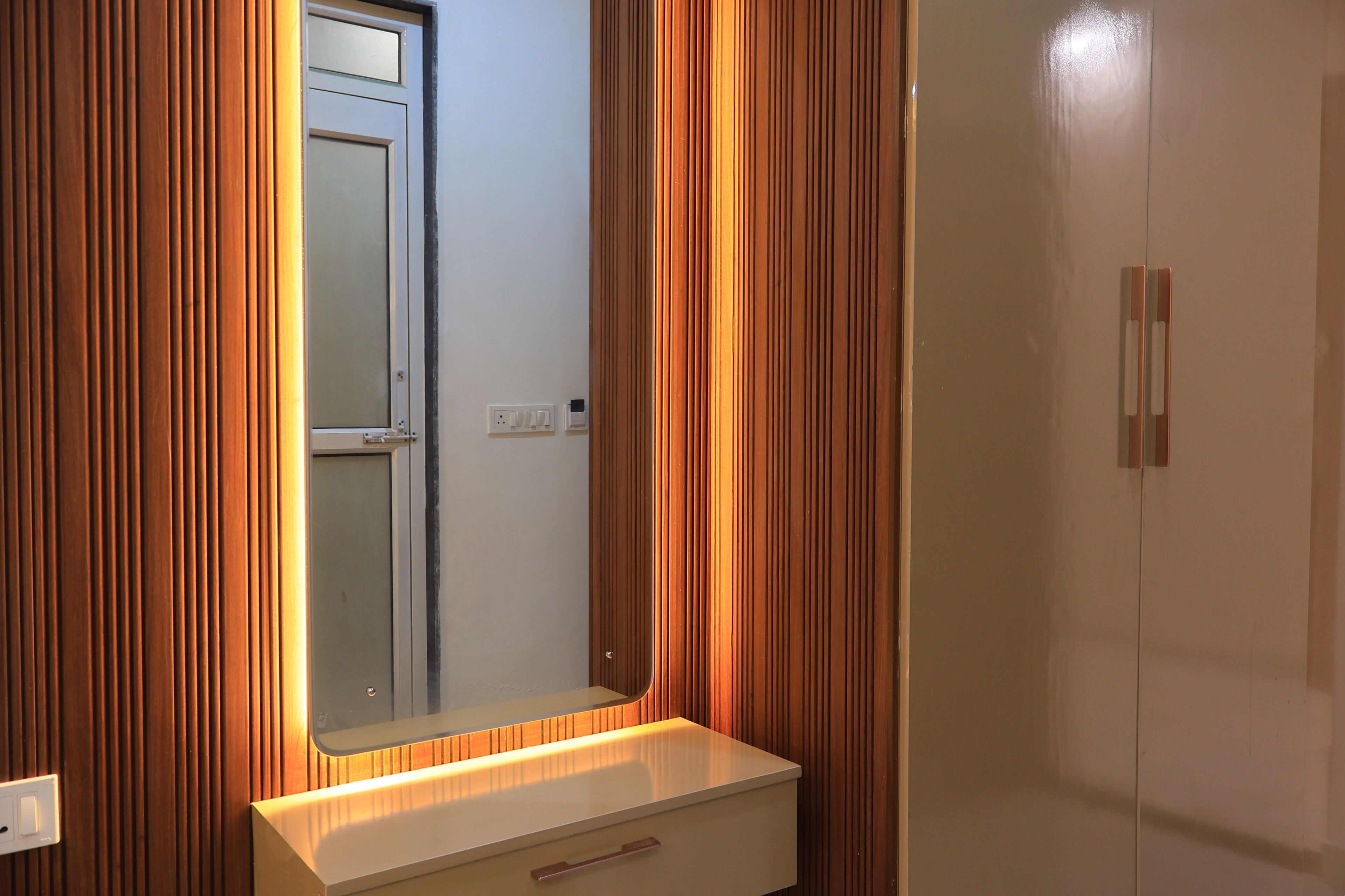 Ein Badezimmer mit Spiegel, Waschtisch und Holzvertäfelung.