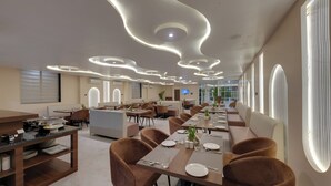 A modern dining area with long tables, brown chairs, and a contemporary ceiling design. - Click Collection Ayodhya (Ayodhya)