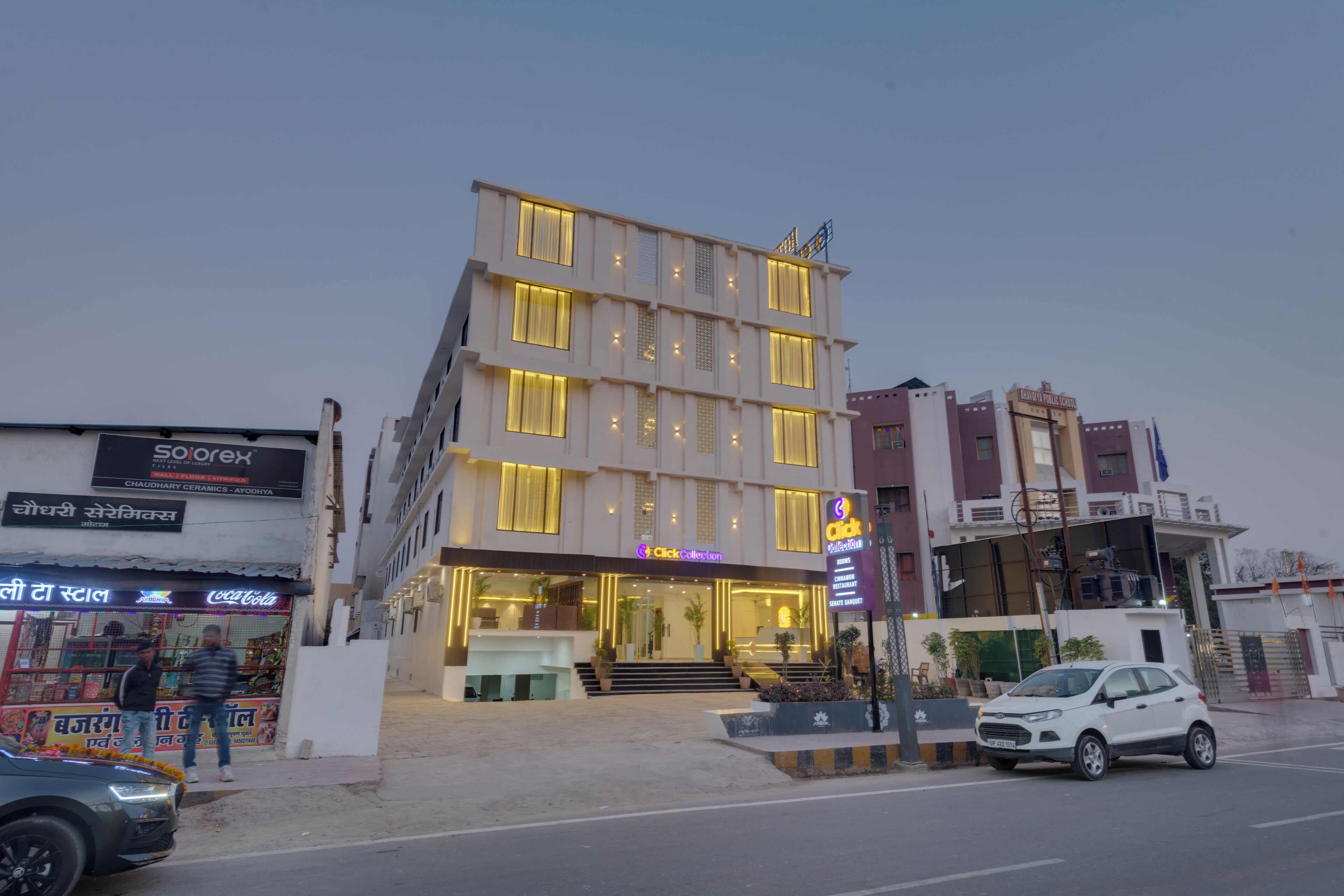 Un hôtel à plusieurs étages, doté d’une façade moderne, d’une entrée bien visible et d’une enseigne Coca-Cola.