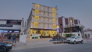 A multi-story hotel with a modern facade, a visible entrance, and a Coca-Cola sign.