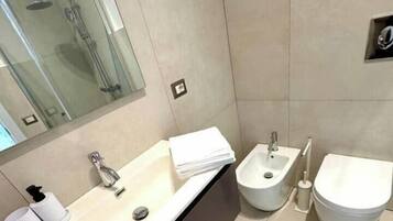 Une salle de bain moderne avec un grand lavabo, un bidet et des toilettes.