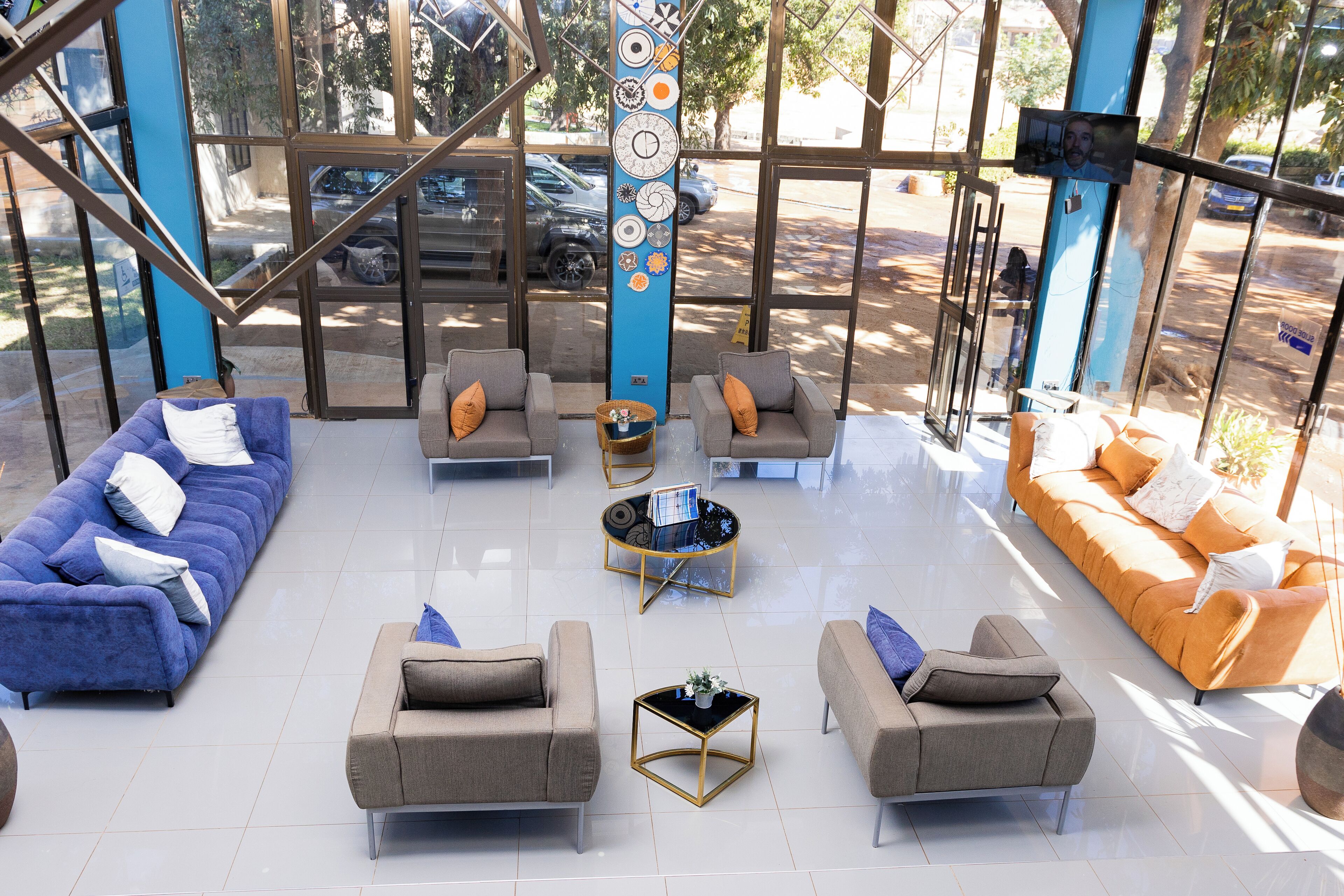 A spacious lobby with a blue and orange sofa set, a coffee table, and a decorative pillar.