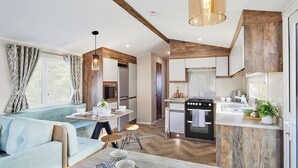 A compact kitchen with a central island, a dining area with a light blue sofa, and a kitchenette with wooden accents.