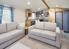 A compact living space with a sofa, kitchenette, and a door. - 2 bedroom accommodation in Hayle (Hayle)