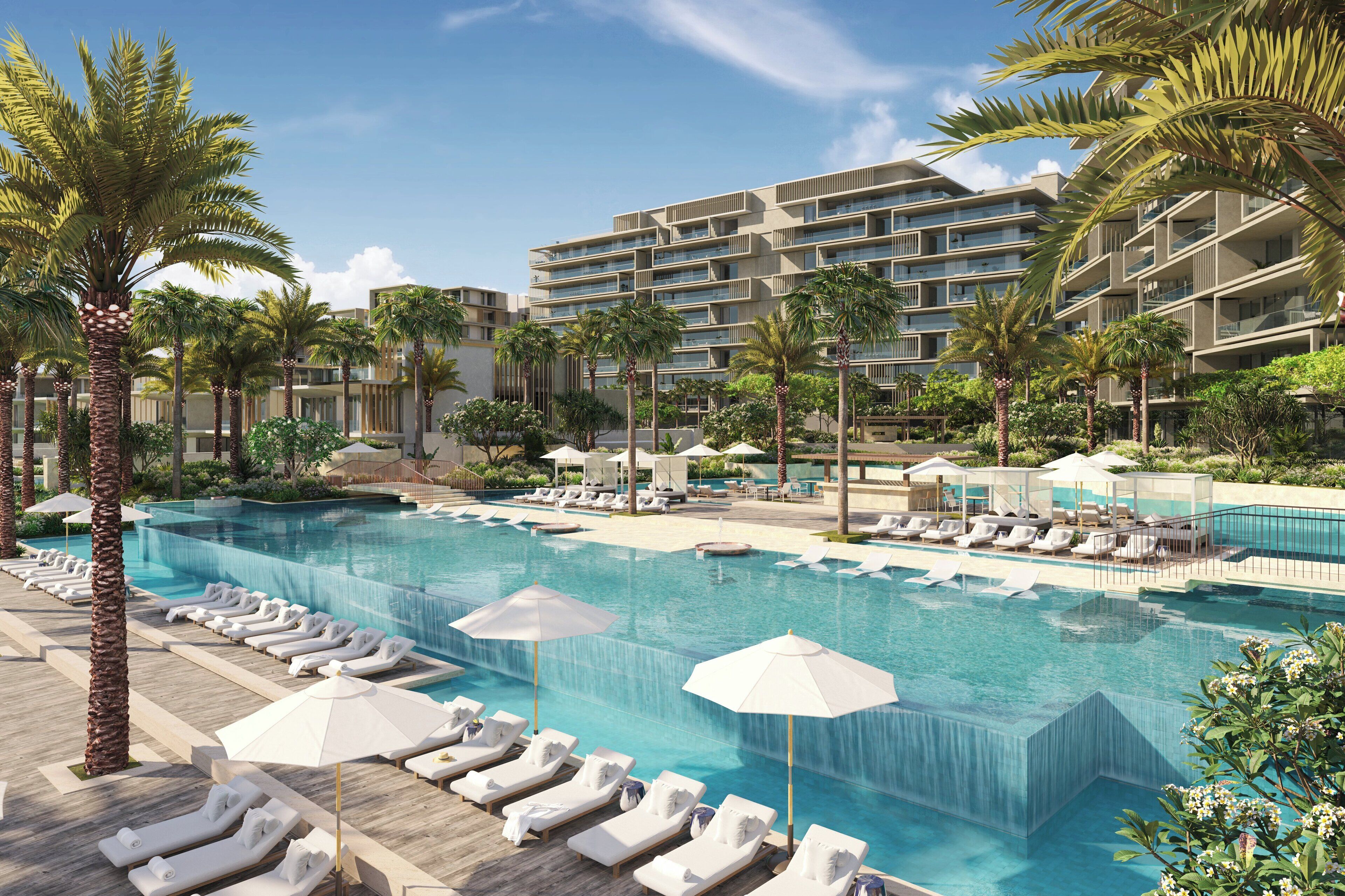 Un hôtel doté d’une piscine, de chaises longues, de palmiers et d’un immeuble à plusieurs étages.
