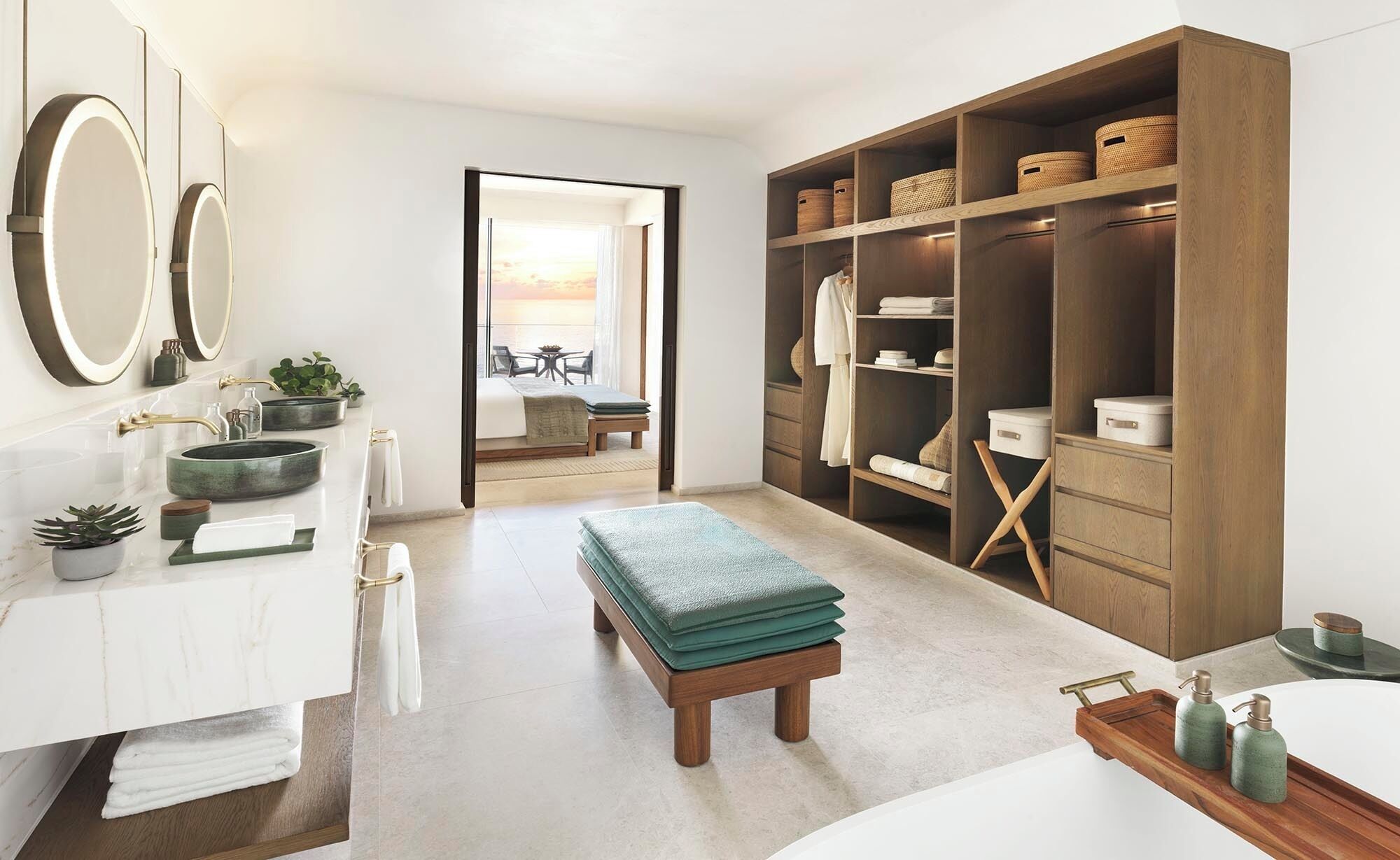 Un bagno moderno con una toeletta, uno specchio grande e un cabina armadio con ripiani e cesti.
