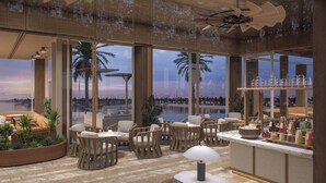 Eine moderne Lounge mit Sitzgelegenheiten, einer Bar und großen Fenstern mit Blick auf ein Gewässer.
