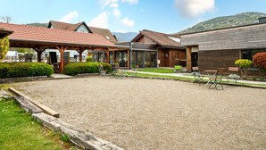 Ett hotell med en takterrass där man kan sitta utomhus, en innergård med grus och utsikt över ett berg.