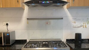 A kitchen with a gas stove, oven, microwave, and a range hood. - Peaceful 4bed all-ensuite apartment in vibrant Nairobi (Nairobi)