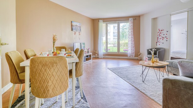 A modern living room with a dining area, large windows, and a view of greenery outside. - Cocoon rose garden (L'Haÿ-les-Roses)