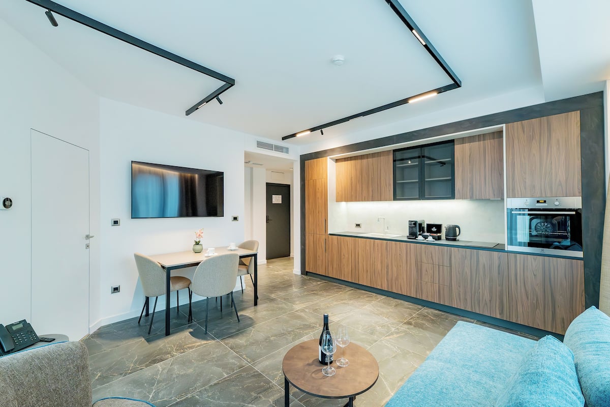 Un espacio habitable moderno con comedor, cocina y sofá.