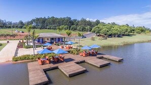 A lakeside resort with wooden docks, outdoor seating, and a clubhouse. - Elegance Santa Bárbara - Vacation Home at Santa Bárbara Resort Residence (Águas de Santa Bárbara)