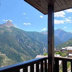 A mountain view from a wooden balcony with a clear sky.