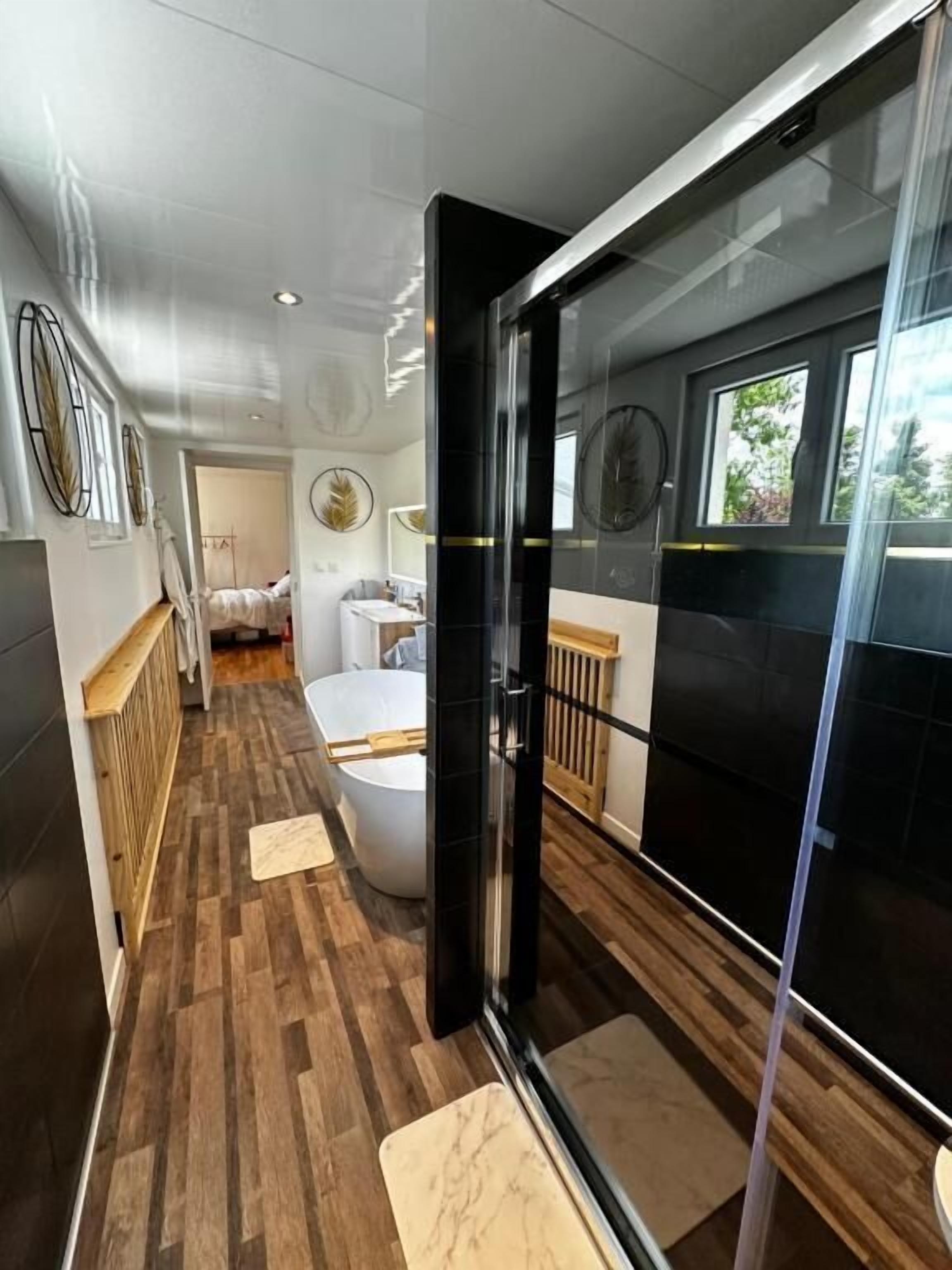 Une salle de bain moderne équipée d’une baignoire, d’une zone de douche et de toilettes.