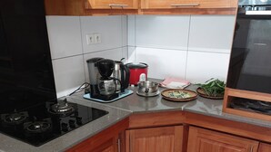 Una cucina con mobili in legno, un forno, una macchina da caffè e un microonde.