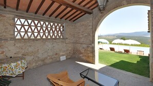 A room with a view of a pool, outdoor seating, and a stone wall. - Tenuta Branca - Podere Apartment with Pool and Terrace in Chianti (San Casciano in Val di Pesa)