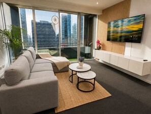 Un salon moderne avec un canapé, une table basse et un téléviseur fixé au mur.