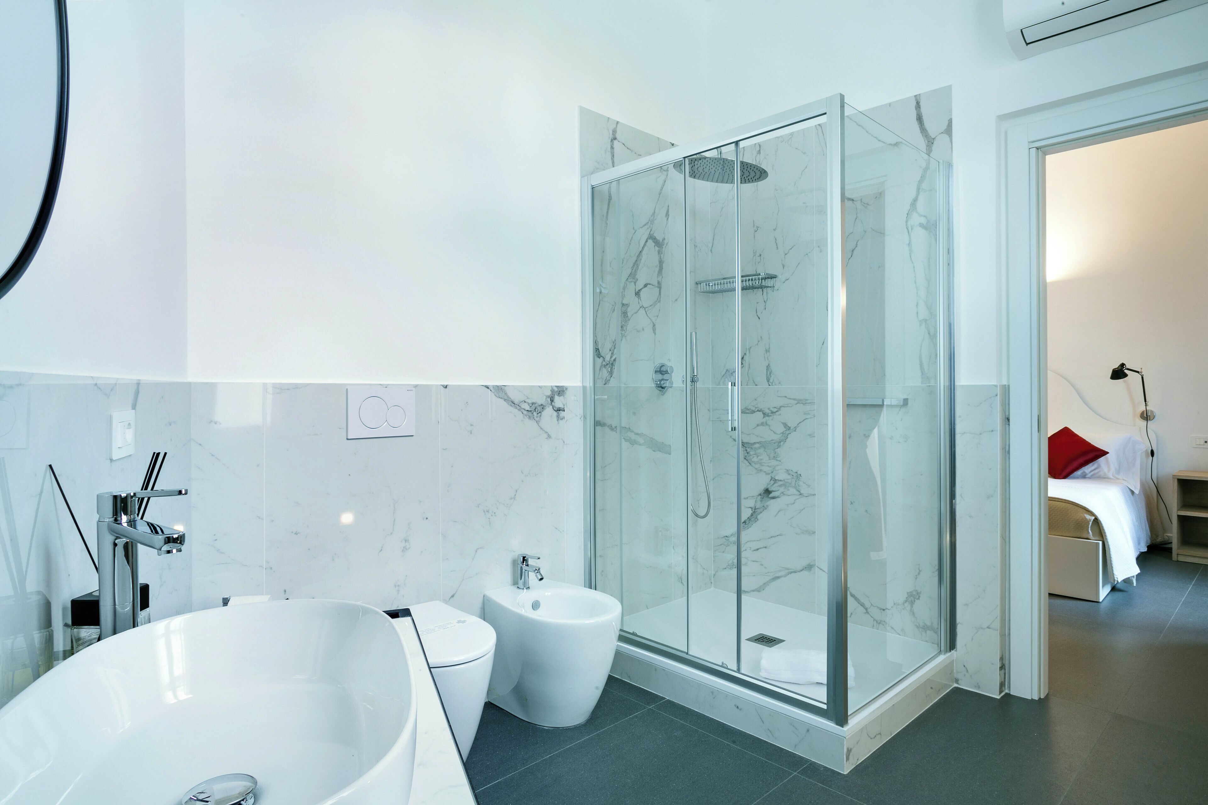 Ein modernes Badezimmer mit einer großzügigen, freistehenden Badewanne, einer gläsernen Duschkabine und einem Bidet.