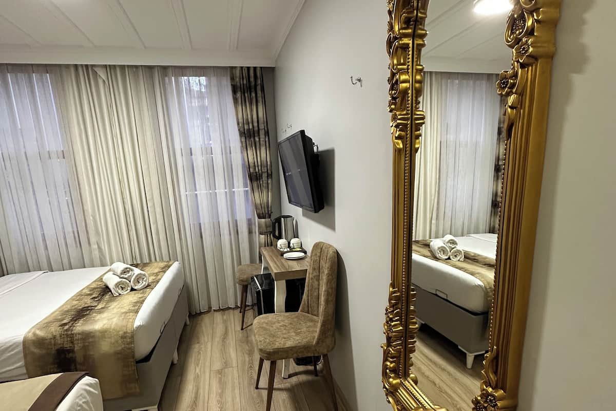 Deluxe Triple Room, Courtyard View | In-room safe, desk, soundproofing, iron/ironing board