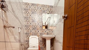 A compact bathroom with a toilet, sink, and shower. - Hotel Kashi Ganga (Bhatwari)