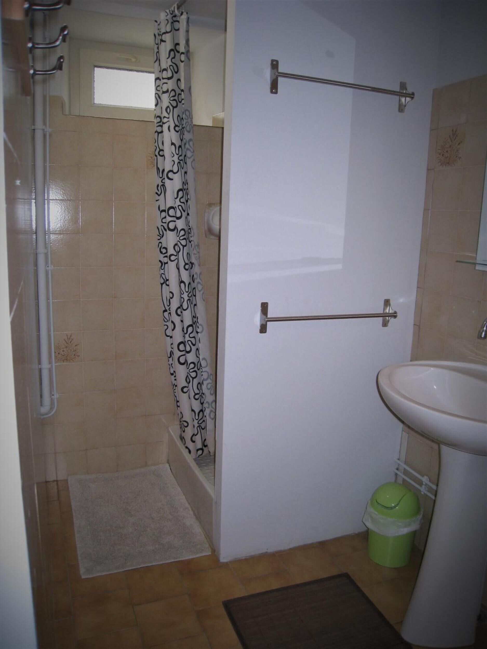 Un baño con ducha, inodoro, lavabo y un toallero.
