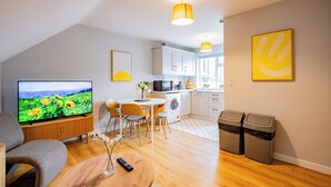 Eine moderne Wohnung mit Wohnzimmer, Essbereich, Küche und Waschraum.