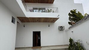 Un edificio moderno con techo de madera, un balcón y una puerta.