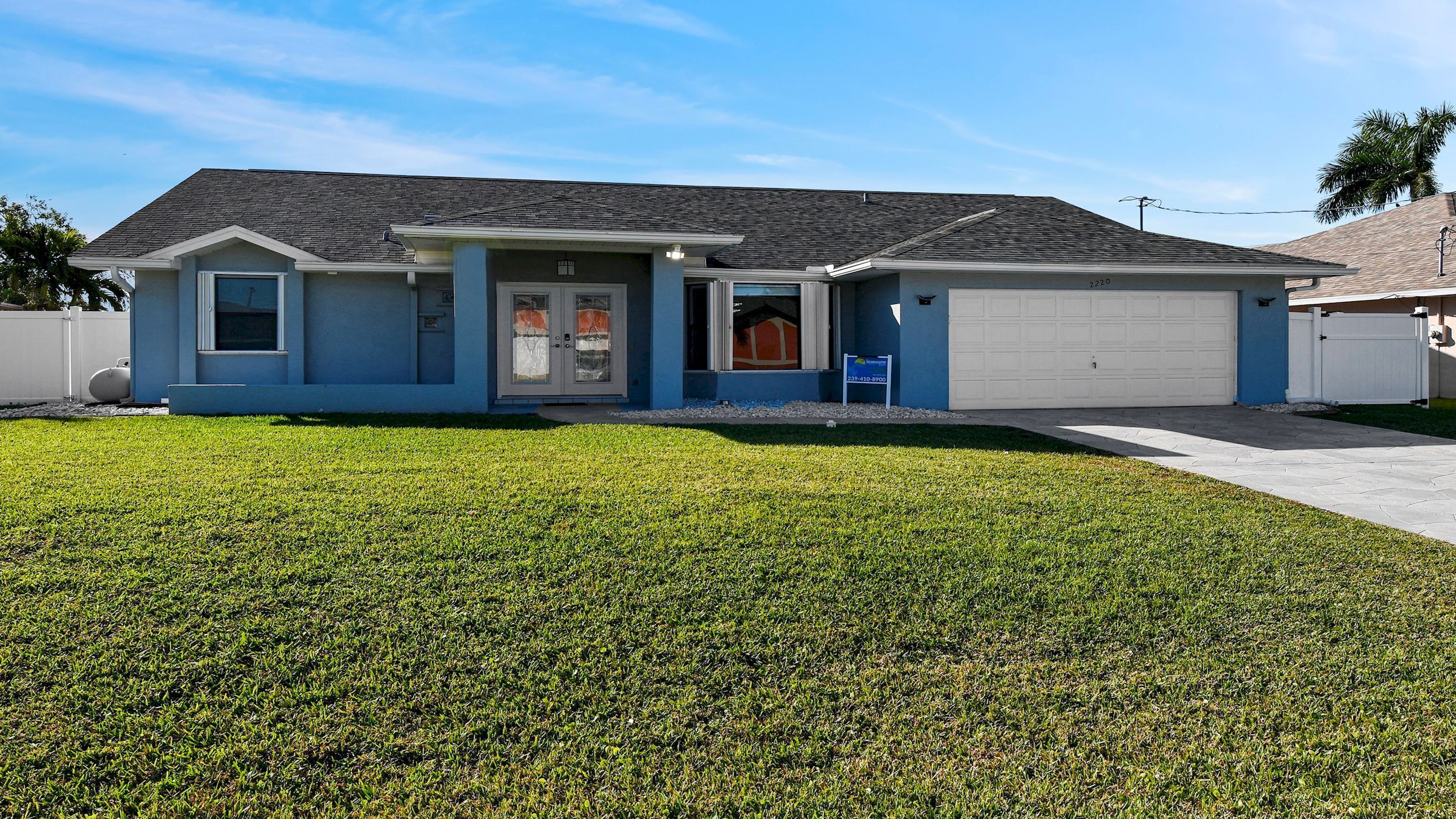 A single-story house with a garage, a front porch, and a well-maintained lawn.