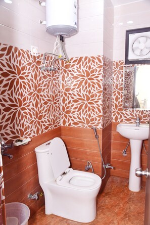 Un baño con inodoro, lavamanos y ducha.