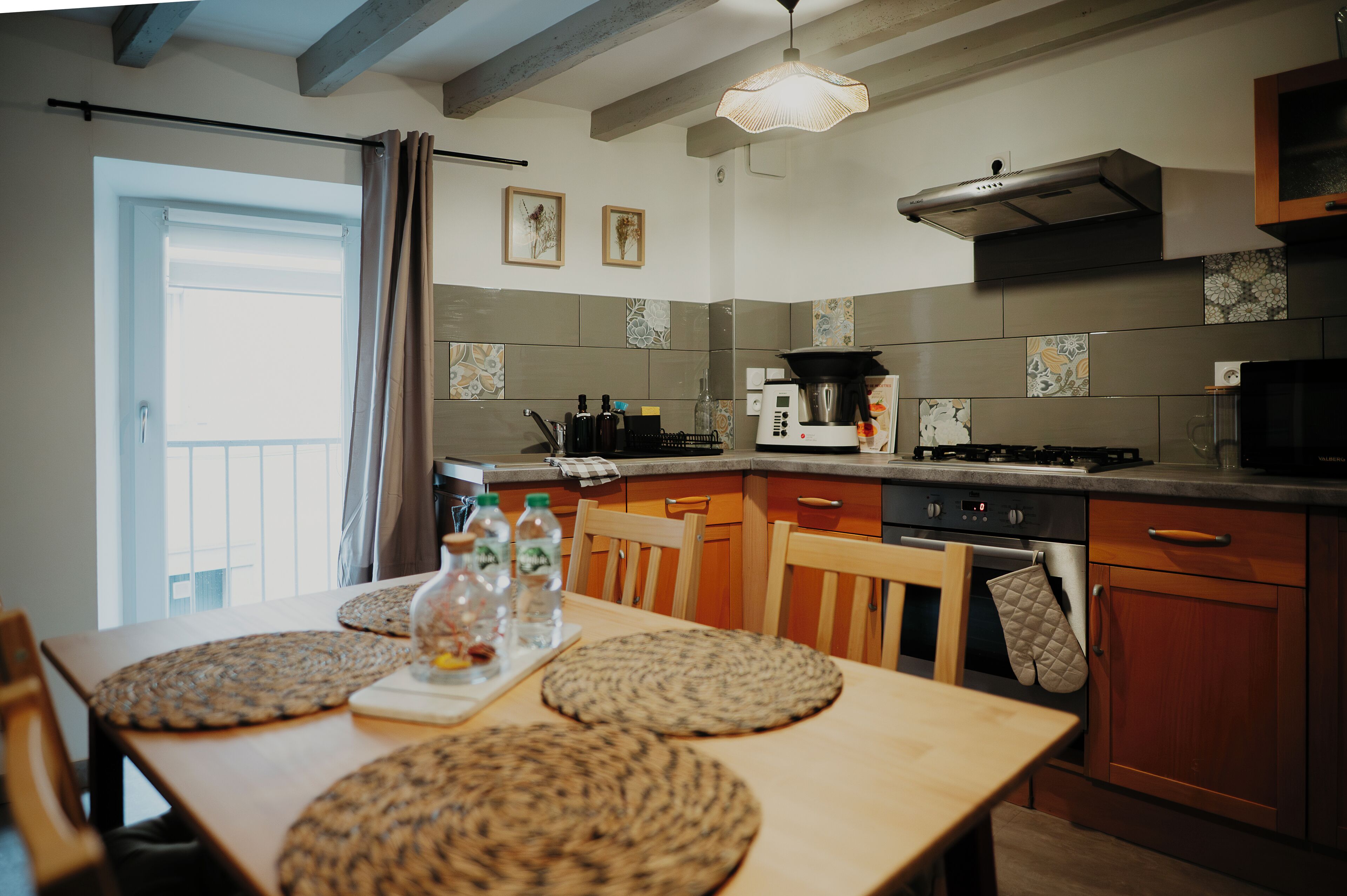Une cuisine équipée d’une table à manger, de chaises, d’une cuisinière, d’un four et d’un four à micro-ondes.