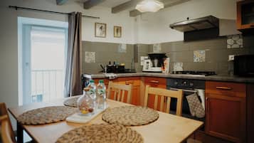 Une cuisine équipée d’une table à manger, de chaises, d’une cuisinière, d’un four et d’un four à micro-ondes.
