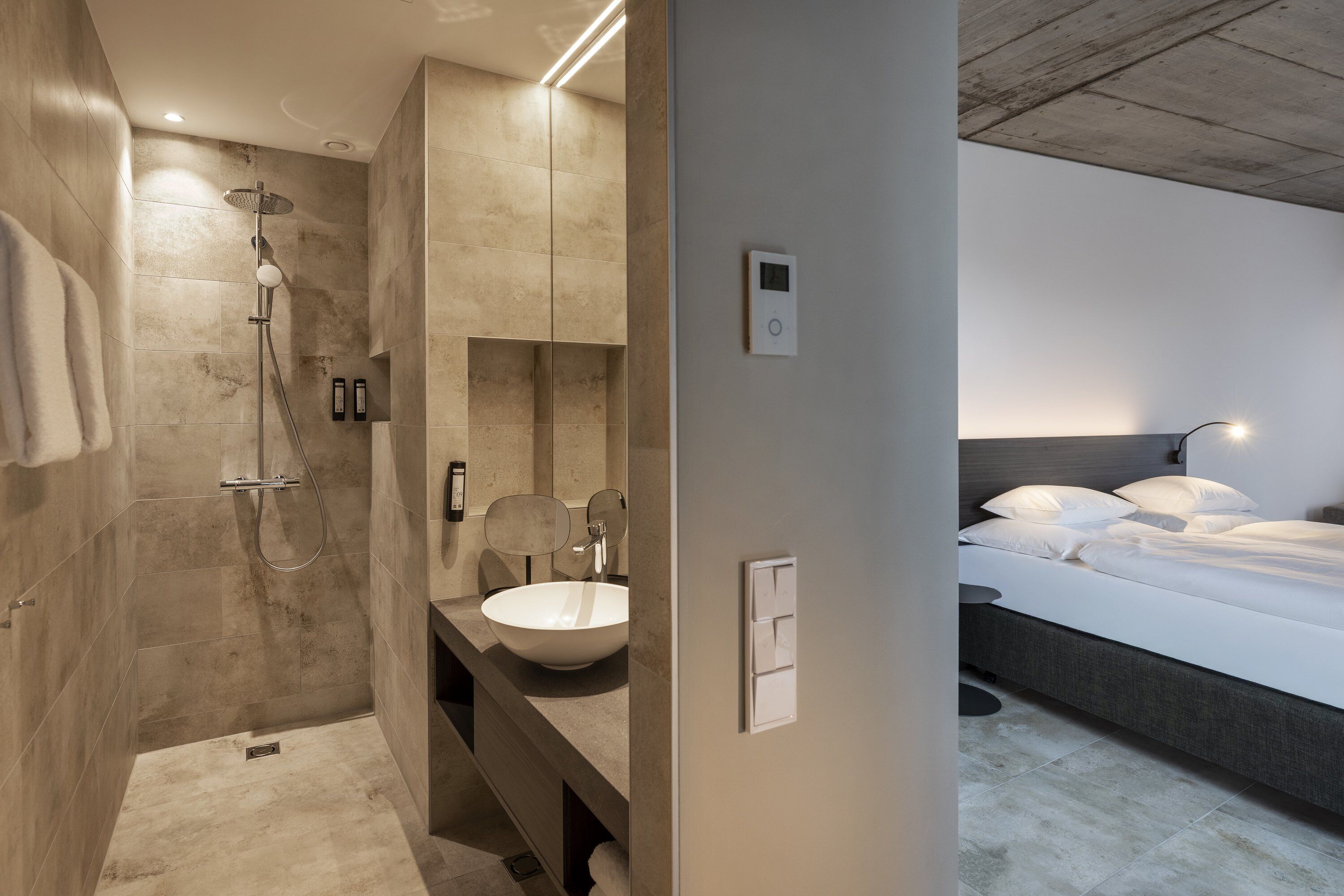 Un bany modern amb plat de dutxa, un gran lavabo i un mirall.