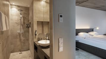 Un bany modern amb plat de dutxa, un gran lavabo i un mirall.