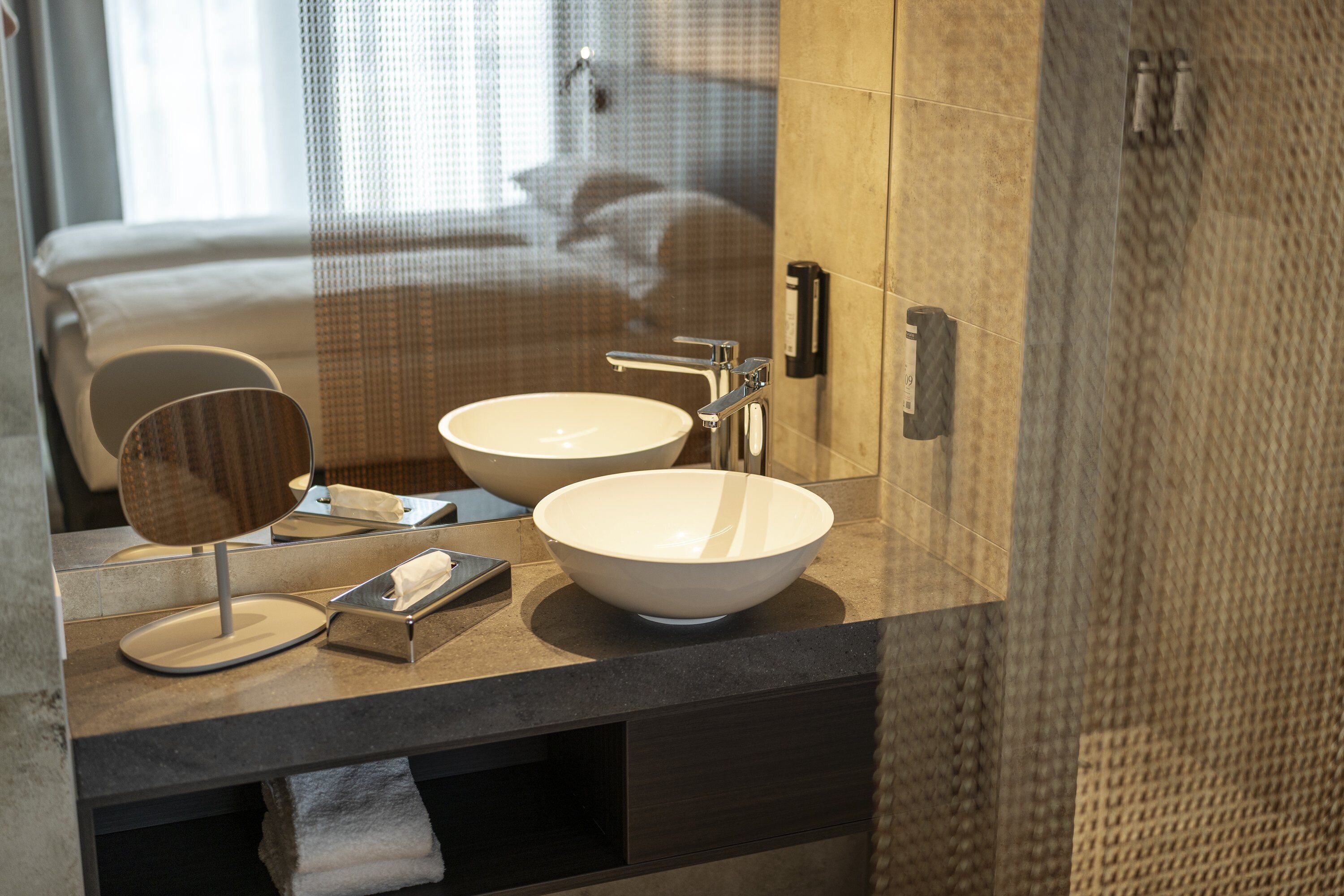 A bathroom with two sinks, a mirror, and a towel rack.