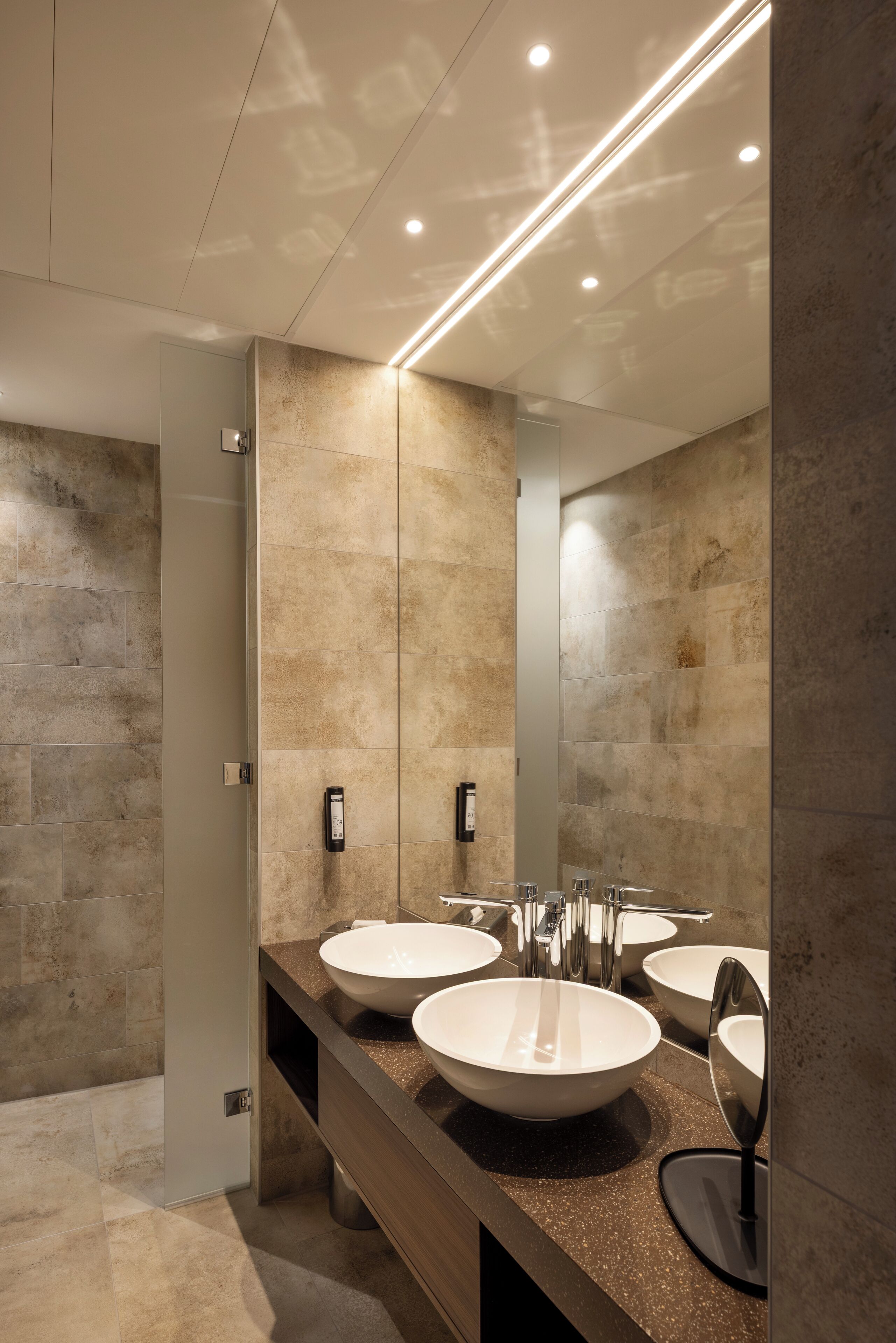 Un baño moderno con dos lavamanos, un espejo grande y un diseño elegante.