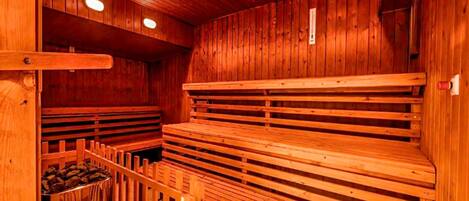 A sauna with wooden benches and a wooden wall.