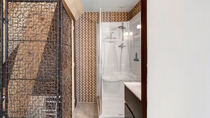 Une salle de bain avec une douche, des toilettes et un lavabo.