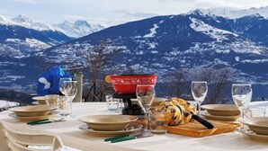 Mesa posta para refeição, com vista para a montanha ao fundo.