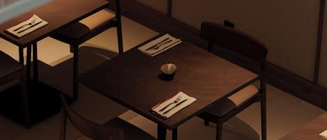 A dining area with tables and chairs, some with menus and cutlery.