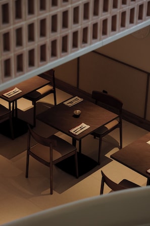 Un comedor con mesas y sillas, algunas con menús y cubiertos.