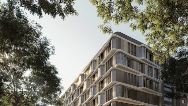Un edificio moderno de varios pisos con fachada curva, grandes ventanales y una entrada a nivel de calle con mesas al aire libre.