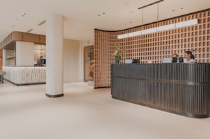 Ein moderner Empfangstresen, eine Kaffeebar und eine Treppe, die in einen oberen Bereich führt.