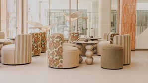 Un interior moderno con asientos redondos, una mesa central y una escalera.