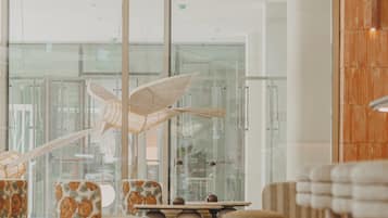 Un interno moderno con ampie finestre, ringhiera in vetro e arredi contemporanei.