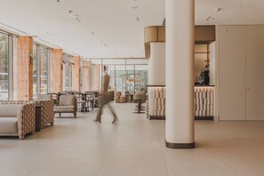 Un interior espaiós amb zona de bar, espais per seure i grans finestres.