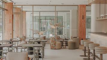A modern interior with wooden accents, glass partitions, and a variety of seating options including tables and chairs.