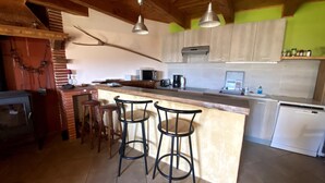 A kitchen with a bar area, wooden ceiling, and tiled floor.